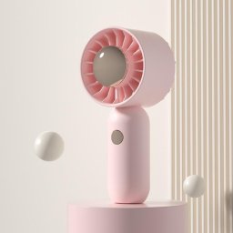 La main tient un petit ventilateur de poche portable, style : version rose avec placage par pulvérisation.