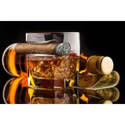 Trabuc cu whisky ținând pahar